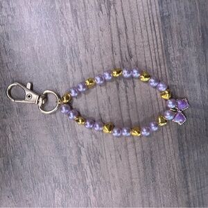 Handmade gold bow keychain with purple and gold hearts!